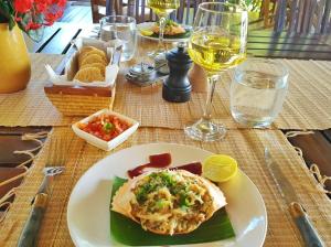 a table with a plate of food and a glass of wine at Ecolodge Nosy Faly in Nosy Be +37 photos