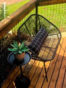 a chair and a table with a pillow on a porch at Tin Town Glamping in Haenertsburg