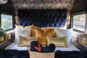 a bedroom with a bed with gold pillows at Tin Town Glamping in Haenertsburg