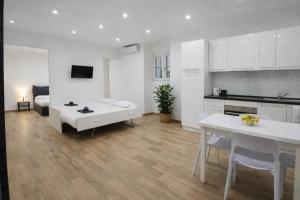 a white living room with a table and a kitchen at Maison TRENCA - fully equiped apartment in Menton +3 photos
