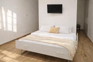 a bed in a room with a tv on the wall at Maison TRENCA - fully equiped apartment in Menton