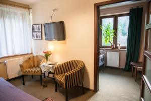 a hotel room with a table and chairs and a tv at Willa Pod Dobrym Humorem in Miedzygorze