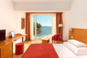 a hotel room with a bed and a view of the ocean at Hotel Zora in Primošten +102 photos