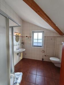 a bathroom with a sink and a toilet and a window at Pension Hafenblick in Barth +48 photos