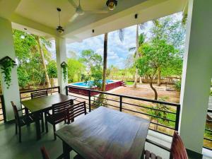 a balcony with a table and chairs and a pool at Eagle Wilpattu Resort in Wilpattu