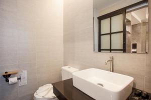 a white bathroom with a sink and a toilet at Ritsurin Boutique Hotel - โรงแรมริทสุริน บูติค in Phuket +36 photos