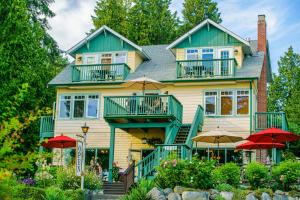 uma casa com guarda-chuvas em frente em Bonniebrook Lodge em Gibsons