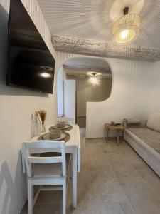 a living room with a white table and a couch at Cocon de Nuit - appartement RDC, avec terrasse in Orange