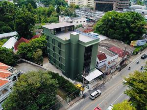 a green building in the middle of a city at Ritsurin Boutique Hotel - โรงแรมริทสุริน บูติค in Phuket