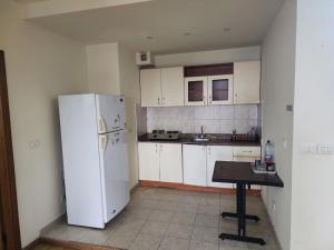 a kitchen with a white refrigerator and a table at HighLand suites in Aley +24 photos