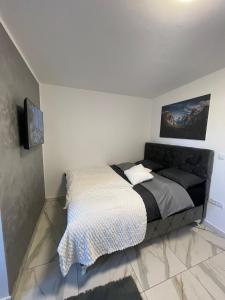 a bedroom with a bed and a tv on a wall at Stan na dan Pecinci in Pećinci