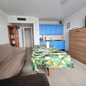 a bedroom with a bed and a kitchen with blue cabinets at Hilo Verde in Matalascañas