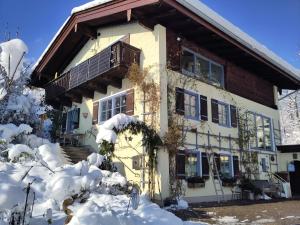 a house in the snow with a balcony at Ferienwohnung Bitterling in Marktschellenberg