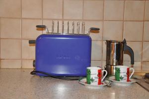 a blue toaster sitting on a kitchen counter with two cups at Ferienwohnung Bitterling in Marktschellenberg