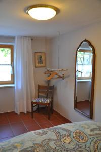 a bedroom with a bed and a mirror and a chair at Ferienwohnung Bitterling in Marktschellenberg