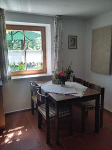 a dining room table with chairs and a window at Ferienwohnung Bitterling in Marktschellenberg