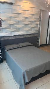 a bed in a room with a wall at Flat Luz in Guarabira