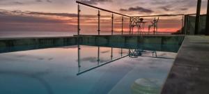 a swimming pool with a sunset in the background at Dolphin Wave in Mossel Bay +25 photos