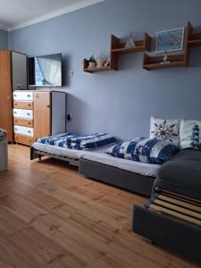 a bedroom with a bed and a dresser in it at Mieszkanie przy plaży Ela in Dziwnów