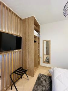 a bedroom with a large flat screen tv on a wall at Onar Apartments in Kalavrita