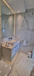 a white bathroom with a sink and a mirror at Dolphin Wave in Mossel Bay