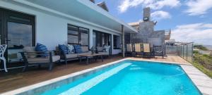 a swimming pool in front of a house at Dolphin Wave in Mossel Bay