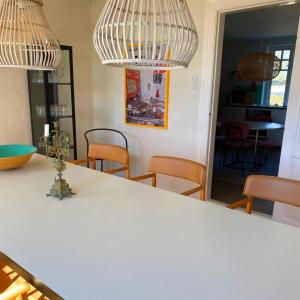 a kitchen with a table with chairs and two chandeliers at Farmhouse in idyllic settings in Ærøskøbing