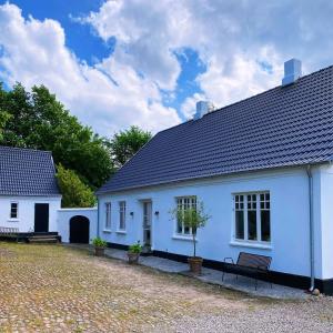 a white house with a bench in front of it at Farmhouse in idyllic settings in Ærøskøbing +11 photos