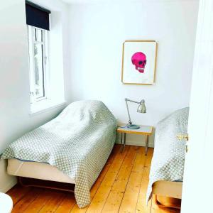 a bedroom with two beds and a lamp on a wooden floor at Farmhouse in idyllic settings in Ærøskøbing