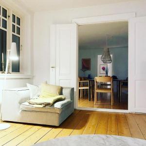 a living room with a couch and a dining room at Farmhouse in idyllic settings in Ærøskøbing