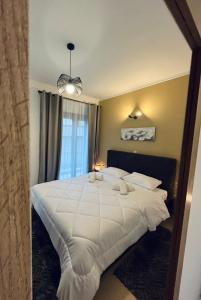 a bedroom with a large white bed with a window at Onar Apartments in Kalavrita