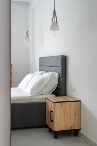 a bedroom with a bed with a wooden box next to it at Atrium The Living Experience in Malia