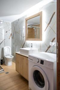 a bathroom with a washing machine and a sink at Atrium The Living Experience in Malia