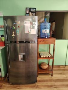 a refrigerator in a kitchen with a shelf next to it at Posada del Carmen 2 in Quillabamba