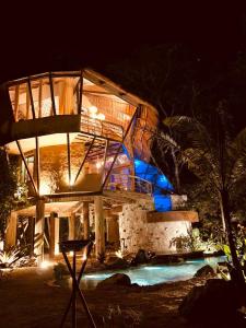 a large building with a swimming pool at night at Satori Zen Club in Itauguá