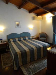 a bedroom with a bed with a striped blanket at B&B luxury San Giuseppe in Gerace +7 photos