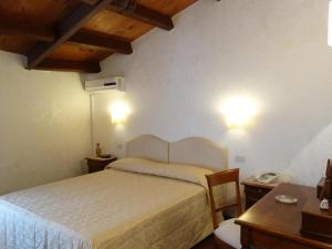 a bedroom with a bed and a table and a desk at B&B luxury San Giuseppe in Gerace