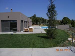 a house with a pool and a tree in the yard at Pikermi garden suite in Pikérmion