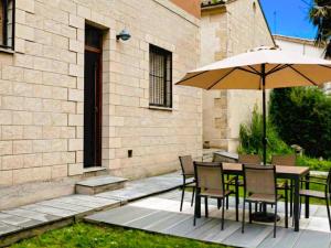 a table and chairs with an umbrella next to a building at Baketxea, 8 PAX, Jardín, BARBACOA y Merendero in Elvillar