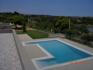 a swimming pool in the middle of a yard at Pikermi garden suite in Pikérmion