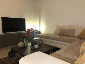 a living room with a couch and a coffee table at Pikermi garden suite in Pikérmion
