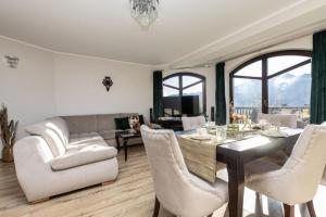 a living room with a table and chairs and a couch at Apartamenty Butorówka Dream 100m2 , Kościelisko - Zakopane in Kościelisko