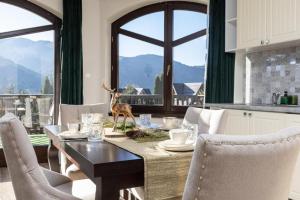 a dining room with a table with a deer statue on it at Apartamenty Butorówka Dream 100m2 , Kościelisko - Zakopane in Kościelisko