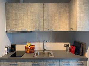 a kitchen with a sink and wooden cabinets at Pikermi garden suite in Pikérmion