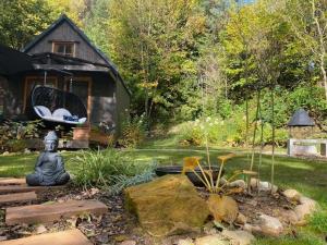a garden in front of a house with a swing at Tiny Resort Chotěvice 2 in Chotěvice