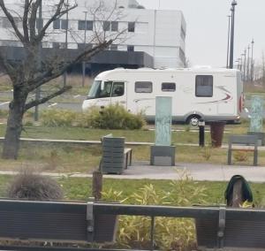a white van parked next to a park with benches at Chambre in Saint-Georges-du-Bois