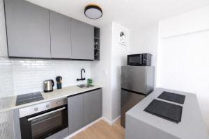 a kitchen with white cabinets and a stainless steel refrigerator at Monoambiente amplio , moderno y super completo in Montevideo