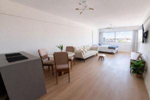 a living room with a couch and a table with chairs at Monoambiente amplio , moderno y super completo in Montevideo