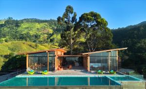 a house with a pool in front of a mountain at Wishing Tree Boutique Resort and Spa - Haputale's Panoramic Hideaway in Haputale