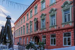 a large red brick building with snow in front of it at Hotel Ptuj in Ptuj